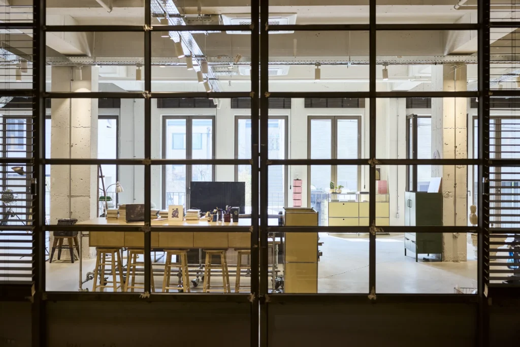 블라인드 창과 대기 공간이 함께 보이는 하루킴 스튜디오 내부 Studio HaruKim interior with window blinds, lounge area and production space